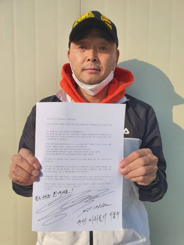 마라토너 이봉주 씨가 칠곡군민들에 보내는 응원편지를 들어보이고 있다. 칠곡군 제공