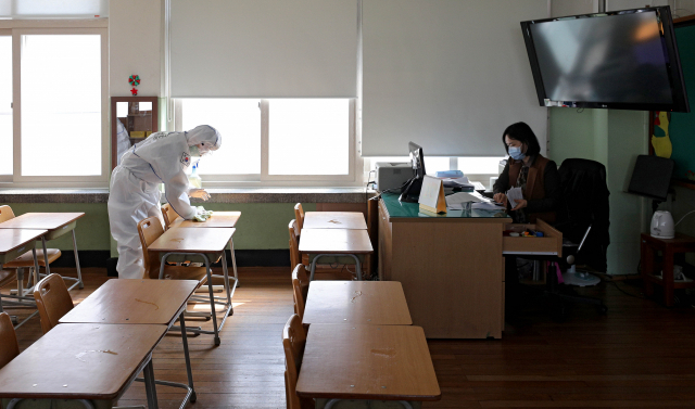 7일 오전 대구 중구 남산초등학교 교실에서 학교 관계자가 온라인 개학을 준비하고 있는 가운데 육군 50사단 장병들이 코로나19 확산 방지를 위한 방역을 하고 있다. 김영진 기자 kyjmaeil@imaeil.com