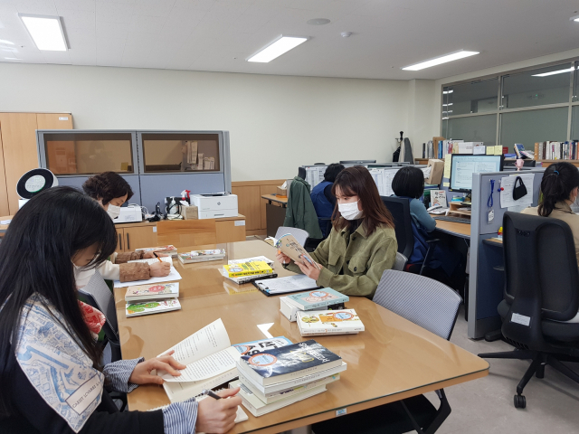 독서활동지를 만들기 위해 책 꾸러미에 포함된 책들을 살펴보고 있는 대구2·28기념학생도서관 직원들 모습. 대구2·28기념학생도서관 제공