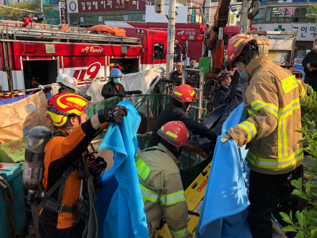 9일 오후 부산 사하구 하단동에서 깊이 4ｍ 하수도 맨홀에서 작업하던 3명이 가스에 중독됐다는 신고가 접수돼 119 구조대원이 구조작업을 하고 있다. 연합뉴스