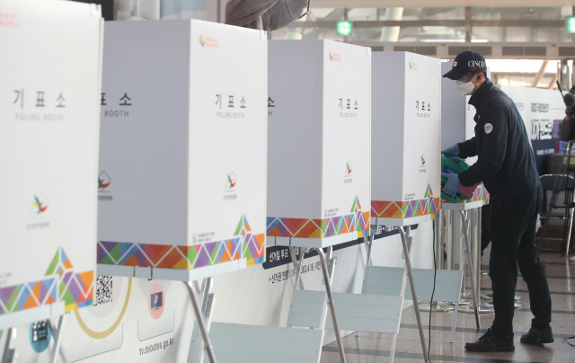 제21대 국회의원선거 사전투표를 하루 앞둔 9일 오후 서울 용산구 서울역 대합실에 설치된 남영동 사전투표소에서 방역 관계자들이 소독 작업을 하고 있다. 연합뉴스