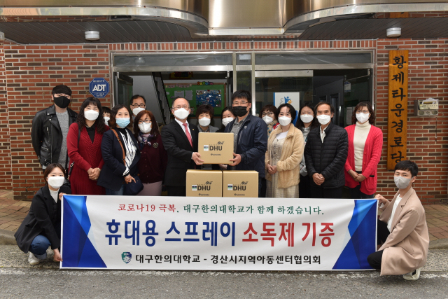 대구한의대 기린봉사단이 만든 휴대용 스프레이 소독제를 경산시지역아동센터협의회에 전달하고 있다. 대구한의대 제공