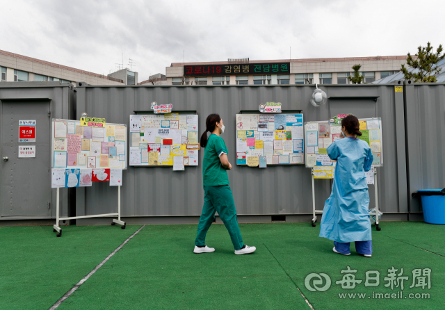 13일 오전 코로나19 감염병 전담병원인 근로복지공단 대구병원에서 병동 근무를 마치고 나온 간호사들이 컨테이너 휴게실 앞에 게시된 전국 각지에서 답지한 응원 메시지를 살펴보고 있다. 우태욱 기자 woo@imaeil.com