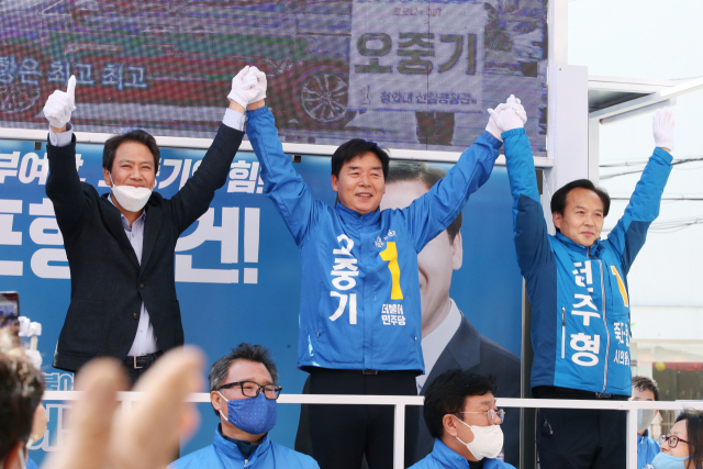 13일 경북 포항 죽도시장에서 임종석 전 대통령 비서실장(왼쪽)이 4·15 총선 포항 북구 선거구에 출마한 더불어민주당 오중기 후보(가운데)와 함께 손을 들고 지지를 호소하고 있다. 연합뉴스