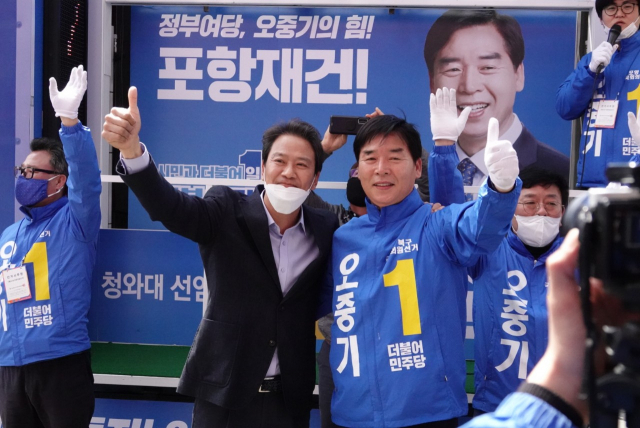 13일 포항 죽도시장을 찾은 임종석 전 대통령 비서실장이 오중기 후보와 손을 흔들고 있다. 민주당 제공