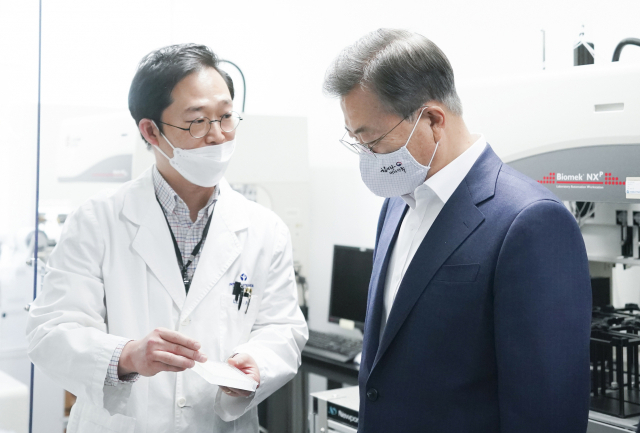 문재인 대통령이 9일 오전 경기도 성남시 한국파스퇴르연구소에서 열린 신종 코로나바이러스 감염증(코로나19) 치료제·백신 개발 산업계·학계·연구소·의료계 합동 회의에 앞서 연구시설에서 이홍근 선임연구원으로부터 화합물 처리과정에 대한 설명을 듣고 있다. 연합뉴스