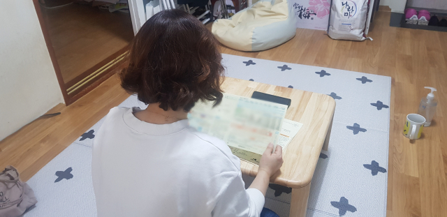 14일 오후 김미숙(가명·50) 씨가 공과금 고지서를 보고 있다. 그는 