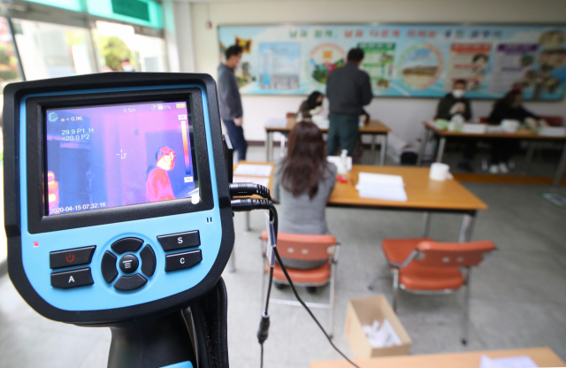 제21대 국회의원 선거일인 15일 오전 대구시 달서구 용전초등학교에 마련된 투표소에 설치된 열화상 카메라가 투표소로 입장하는 시민들의 체온을 체크하고 있다. 연합뉴스