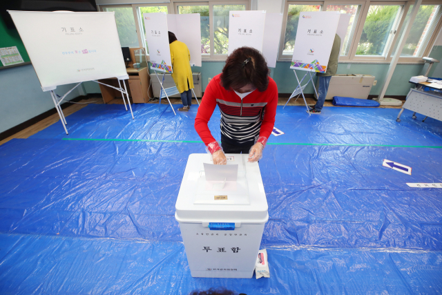제21대 국회의원 선거일인 15일 오전 대구시 달서구 성서중학교에 마련된 투표소에서 한 시민이 투표함에 투표용지를 넣고 있다. 연합뉴스