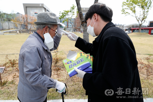 제21대 국회의원 선거일인 15일 대구 북구 산격3동 제2투표소에서 선거사무원이 유권자의 발열 여부를 체크하고 있다. 우태욱 기자 woo@imaeil.com