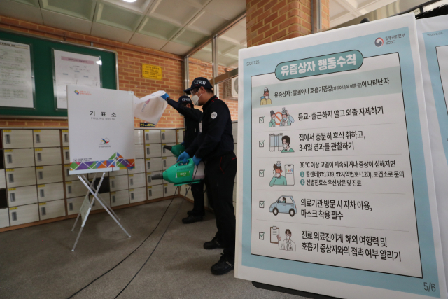 제21대 국회의원 선거를 하루 앞둔 14일 오후 청운효자동 제1투표소인 서울 청운초등학교에 별도로 마련된 발열 증상자 및 자가격리자 기표소에서 관계자들이 방역작업을 하고 있다. 연합뉴스