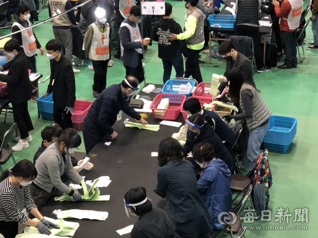 15일 대구 중구 성명여중 강당 개표소에서 선거사무원들이 마스크와 장갑, 페이스가드 등을 착용하고 개표 작업을 하고 있다. 김근우 기자