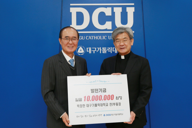 박정한 전 부총장(사진 왼쪽)이 김정우 총장에게 발전기금을 전달하고 있다. 대구가톨릭대 제공