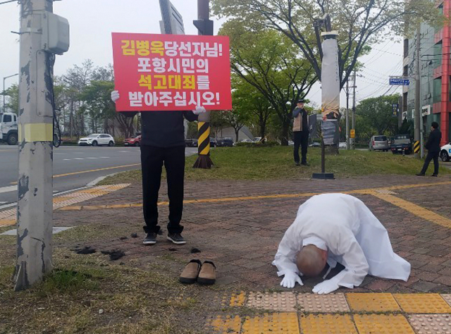 17일 경북 포항시 남구 형산교차로에서 더불어민주당 소속 이재도 도의원이 삭발한 뒤 엎드려 절을 하고 있다.