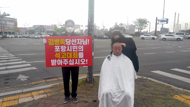 17일 경북 포항시 남구 형산교차로에서 더불어민주당 소속 이재도 도의원이 삭발하고 있다. 이 도의원은 삭발 후 엎드려 절을 하는 이른바