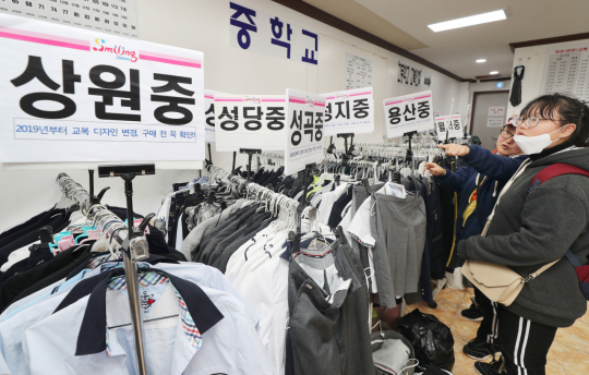 지난 2월 12일 대구 달서구 월성종합사회복지관에 마련된 달서교복나눔 상설판매장을 찾은 예비 중학생과 엄마가 배정된 중학교 교복을 고르고 있다. 성일권 기자 sungig@imaeil.com