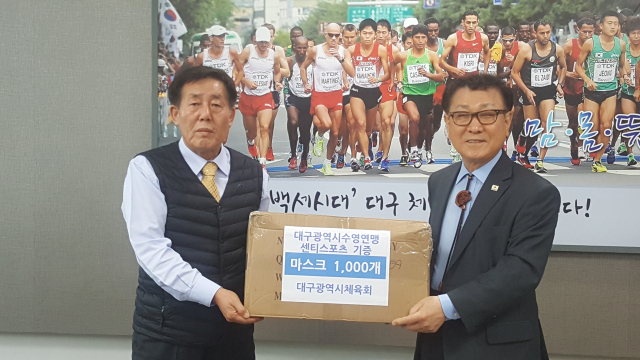 대구시수영연맹(회장 남정달·오른쪽)은 18일 대구시체육회를 찾아 코로나19 감염 확산 방지를 위한 마스크 1천장을 기부했다. 대구시체육회 제공.