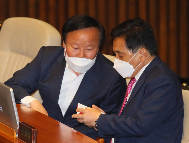 미래통합당 심재철 원내대표(오른쪽)와 김재원 정책위의장이 20일 국회 본회의장에서 논의하고 있다. 연합뉴스