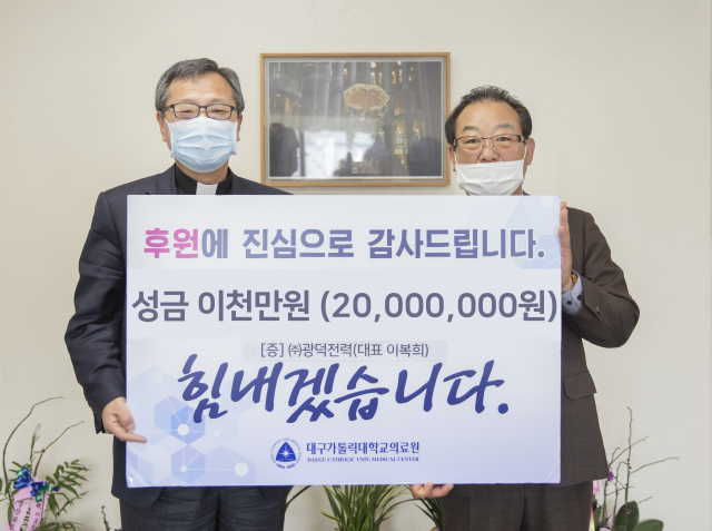 이복희 광덕전력 대표이사(오른족)가 송재준 대구가톨릭대의료원장에게 코로나19 극복성금을 전달하고 있다. 대구가톨릭대병원 제공