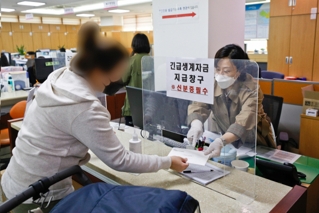 대구시 긴급생계자금 지급이 시작된 10일 달서구 진천동 행정복지센터에서 주민이 정액형 선불카드가 든 봉투를 수령하는 모습. 매일신문 DB