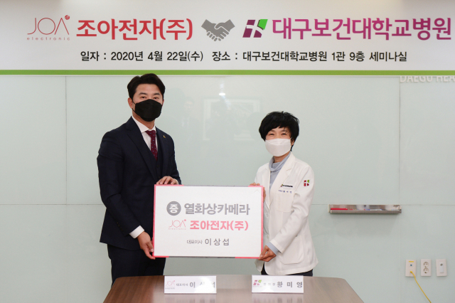 이상섭 조아전자 대표(왼쪽)가 22일 오전 10시 대구보건대학교병원 1관 9층 세미나실에서 열화상 카메라 기증식을 개최한 가운데 황미영 병원장(오른쪽)과 기념촬영을 하고 있다. 대구보건대 제공