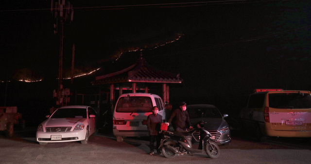 지난 24일 발생해 소강상태를 보이던 안동 산불이 강한 바람에 재확산한 25일 오후 경북 안동 남후면 고하리에서 마을주민들이 화재를 피해 대피해 있다. 김영진 기자 kyjmaeil@imaeil.com