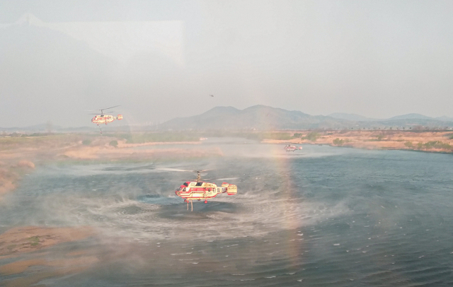 안동 산불을 진화하고자 산림청 산불진화헬기들이 인근 낙동강에서 급수를 하고 있다. 경북도 제공