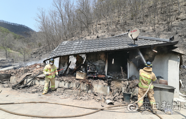 지난 26일 안동시 남후면 고하리의 산불로 시커멓게 타버린 농가에서 소방대원들이 잔불을 정리하고 있다. 성일권 기자 sungig@imaeil.com