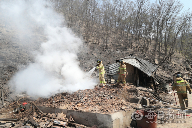 26일 안동시 남후면 고하리의 산불로 시커멓게 타 버린 한 농가에서 소방대원들이 잔불을 정리하고 있다. 성일권 기자 sungig@imaeil.com
