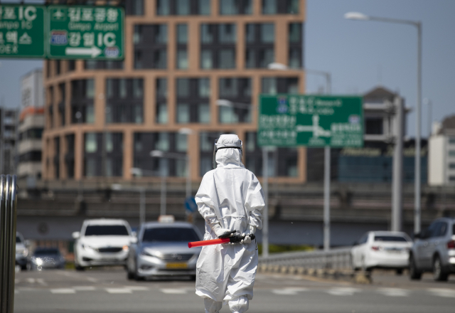 지난 26일 잠실주경기장 주차장 드라이브스루 선별진료소에서 관계자들이 업무를 보고 있다. 연합뉴스