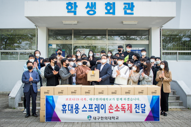변창훈 총장은 27일 학생회관에서 이재익 총학생회장에게 재학생 전원에게 지급할 휴대용 스프레이 손소독제를 전달하고 있다. 대구한의대 제공