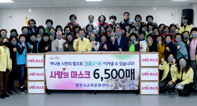 영천시 교육문화센터 소속 자원봉사자들이 취약계층 등을 위해 제작한 사랑의 면마스크 전달식 모습. 영천시 제공