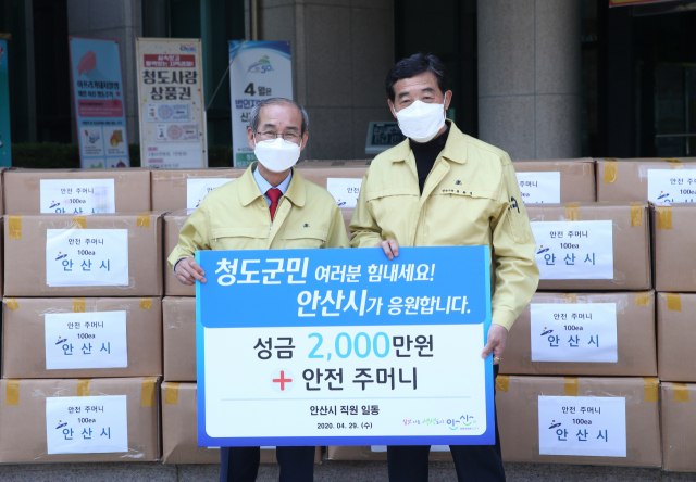 경북 청도군과 자매결연을 추진 중인 경기도 안산시 윤화섭(오른쪽) 시장이 29일 청도군 이승율 군수에게 코로나19 극복 성금과 방역물품을 전달하고 있다. 청도군 제공