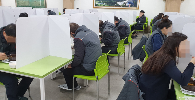 SK울산콤플렉스 구내식당에서 직원들이 칸막이가 설치된 식탁에 앉아 식사를 하고 있다. 이 회사는 코로나19 확산 차단을 위해 점심시간 3부제, 식당 칸막이 설치 등을 시행하고 있다. 연합뉴스