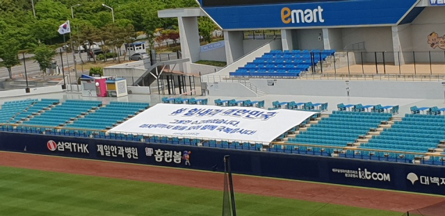 프로야구 개막을 하루 앞둔 4일 대구 수성구 연호동 삼성라이온즈피크 관중석에 코로나19 극복을 위한 격려문구가 담긴 플래카드가 설치돼 있다. 내일 이곳에서 열리는 삼성과 NC의 개막전은 무관중 경기로 진행된다.