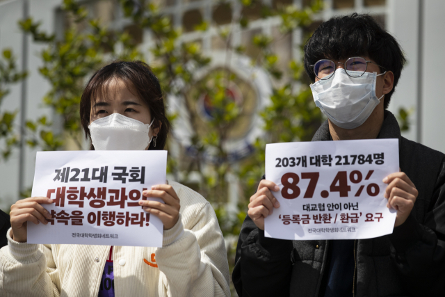 지난달 21일 정부서울청사 앞에서 열린 기자회견에서 전국대학학생네트워크 회원들이 등록금 반환 관련 내용이 적힌 손피켓을 들고 있다. 연합뉴스