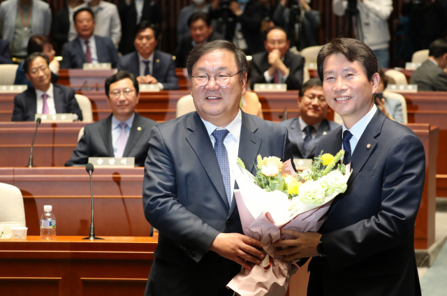 더불어민주당 김태년 신임 원내대표(왼쪽)가 8일 오후 서울 여의도 국회에서 열린 의원총회에서 이인영 전 원내대표에게 꽃다발을 전달하고 있다. 연합뉴스