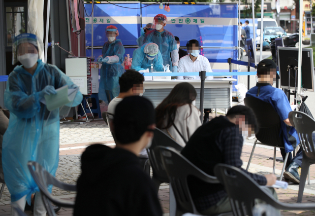이태원 클럽발 신종 코로나바이러스 감염증(코로나19) 집단감염이 급증하고 있는 지난 11일 오후 서울 영등포구 보건소 선별진료소에서 의료진이 검사하고 있다. 연합뉴스