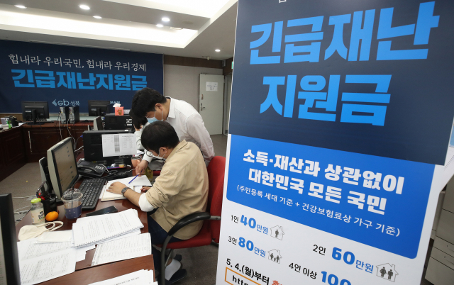 12일 서울 성북구청에서 직원들이 긴급재난지원금 신청과 관련해 안내, 상담을 하고 있다. 연합뉴스