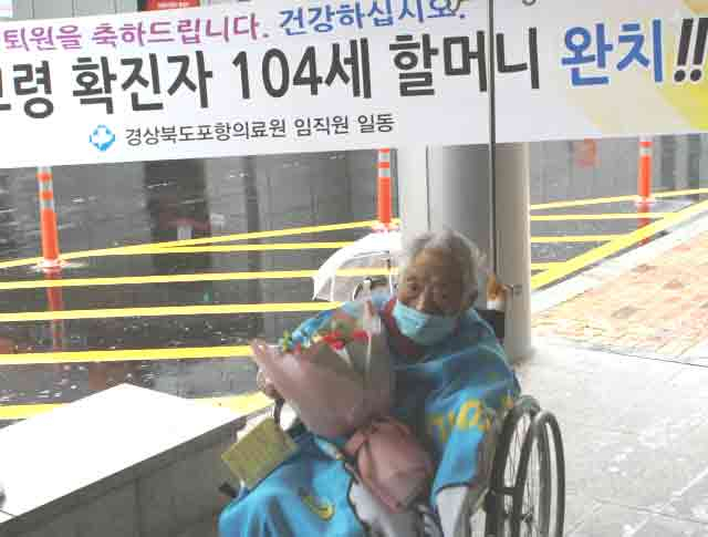 코로나19 국내 최고령 환자인 104세 할머니가 67일간 치료를 마치고 포항의료원 의료진들의 환영속에 15일 병원을 나서고 있다. 포항의료원 제공