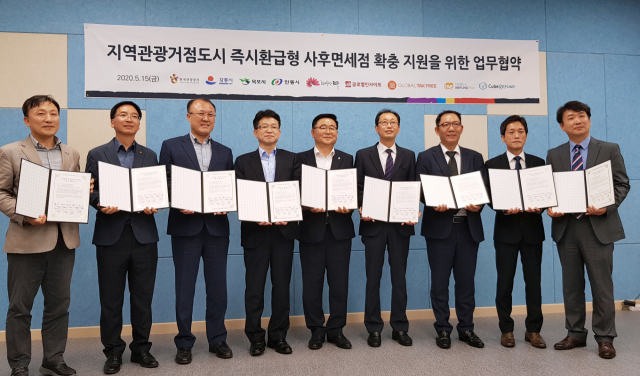 지역관광거점도시 즉시환급형 사후면세점 확충을 위해 김병태 안동시 관광진흥과 관광거점도시사업팀장(왼쪽 세 번째)과 관계자들이 15일 서울 용산 비앤디파트너스 비즈니스센터에서 업무협약서를 들고 포즈를 취하고 있다. 안동시 제공
