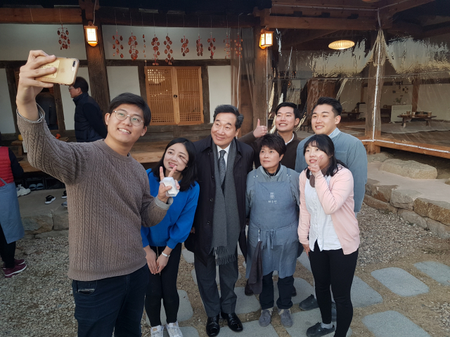 이낙연 전 국무총리가 지난해 12월 31일 도시 청년들이 문경에 정착해 운영하는 문경 화수헌 카페를 찾아 화수헌 청년 멤버들의 인증샷에 응하고 있다. 고도현 기자