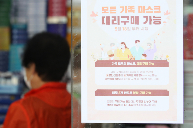 18일 서울 종로구의 한 약국에 공적마스크 대리구매 관련 안내문이 붙어 있다. 이날부터 가족 한명이 본인의 신분증과 가족관계증명서를 지참하면 모든 가족의 마스크를 대리 구매할 수 있다. 연합뉴스