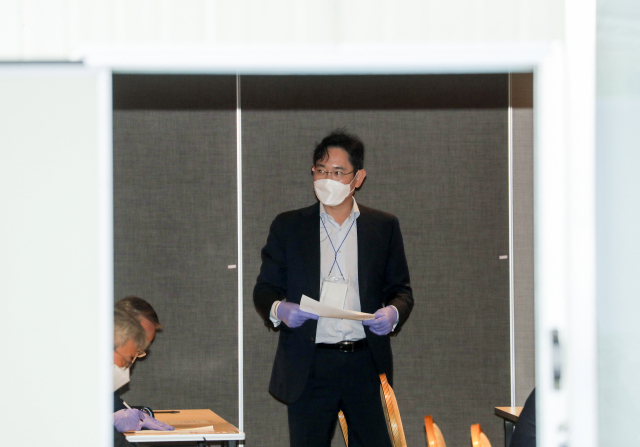 중국 시안 반도체 공장 방문을 마치고 김포공항을 통해 귀국한 이재용 삼성전자 부회장이 19일 오후 김포공항 인근 대기 장소에서 코로나19 검사를 받기 전 문진표를 작성해 제출하고 있다. 연합뉴스