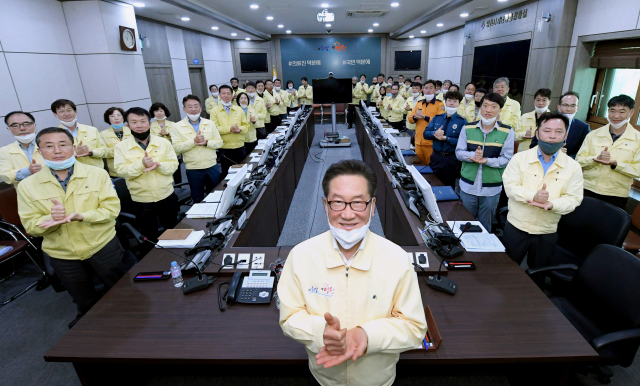 최기문 시장을 비롯한 영천시 공무원과 영천소방서, 영천경찰서 등 각급 기관단체 관계자들이 유관기관 합동대책회의에 앞서 코로나19 조기 극복을 기원하는 퍼포먼스를 하고 있다. 영천시 제공