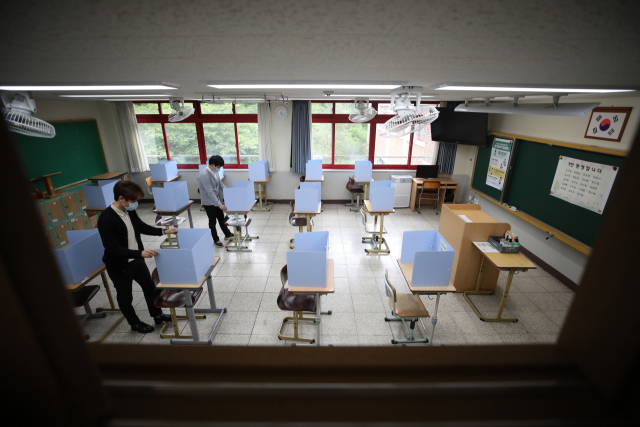 고등학교 3학년 학생들의 등교를 하루 앞둔 지난 19일 대구시 수성구 정화여자고등학교 3학년 교실에서 담임 선생님 등이 신종 코로나바이러스 감염증(코로나19) 확산방지를 위해 책상마다 설치된 가림막을 살펴보고 있다. 연합뉴스