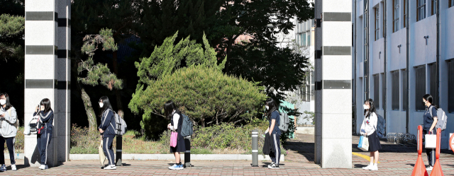 코로나19로 미뤄진 등교 수업이 다시 시작된 20일 오전 대구 중구에 있는 경북여자고등학교에서 고3 학생들이 한줄로 간격을 띄우고 등교하고 있다. 김영진 기자 kyjmaeil@imaeil.com