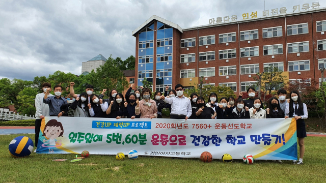 안동 경안여자고등학교 학생과 교직원들이 코로나19를 이기기 위한 면역력 강화 프로그램의 일환으로 시행되는 7560 운동 프로그램에 대한 현수막을 들고 기념촬영을 하고 있다. 경안여고 제공