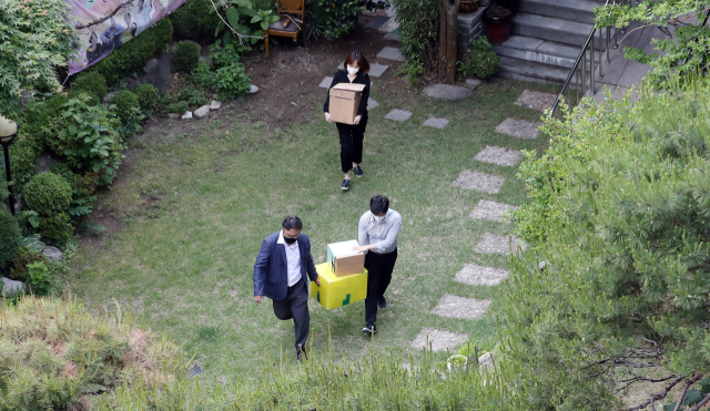 정의기억연대 부실회계·안성 쉼터 고가 매입 의혹을 수사 중인 검찰이 21일 오후 서울 마포구 정의기억연대 피해자 할머니 쉼터에서 압수수색을 마친 뒤 박스를 들고 가고 있다. 연합뉴스