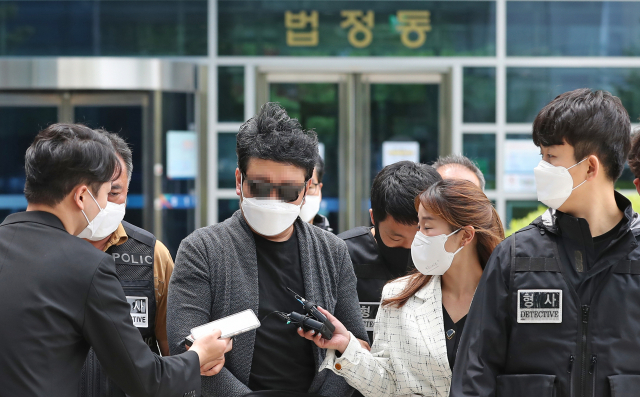 강북구 아파트 경비원 고 최희석 씨를 폭행한 혐의를 받는 주민이 22일 오전 구속 전 피의자 심문(영장실질심사)을 마친 후 서울 도봉구 서울북부지법을 나서고 있다. 연합뉴스